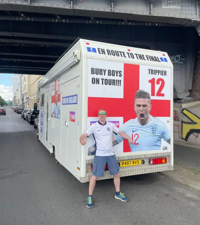 Fan poses behind a Kieran Trippier themed campervan