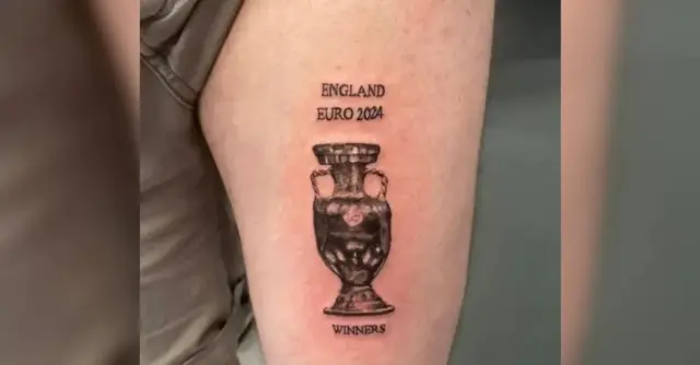 Man's leg with tattoo saying 'England Euro 2024 winners' and image of trophy.