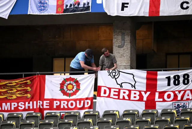 England fans hang flags in the ground