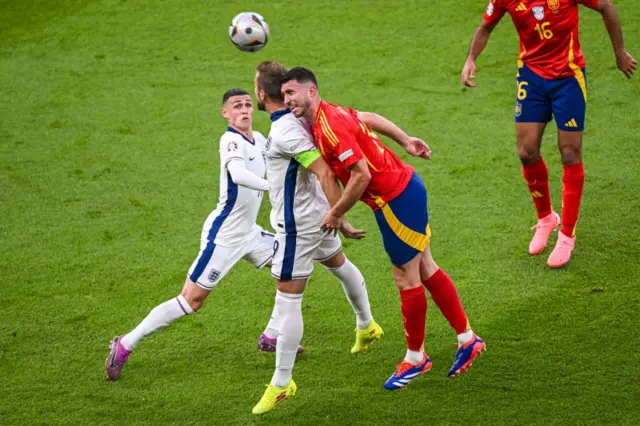 Laporte wins a header above Kane and Foden