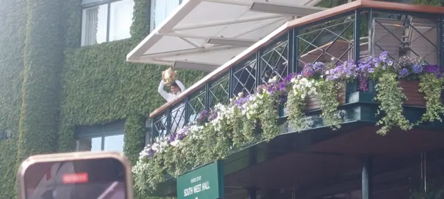 Carlos Alcaraz holding the Wimbledon trophy