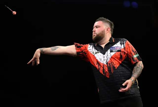 Michael Smith throws a dart