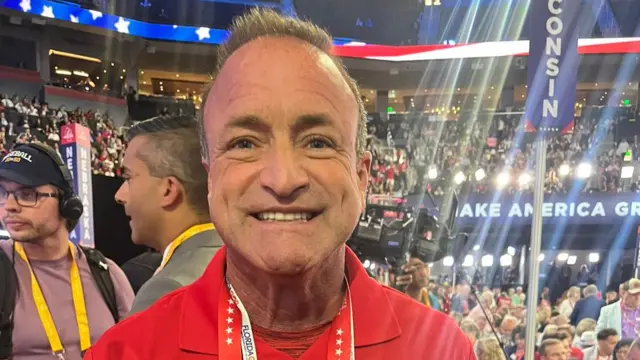 Joe Mullins smiles at camera in a crowd at the convention