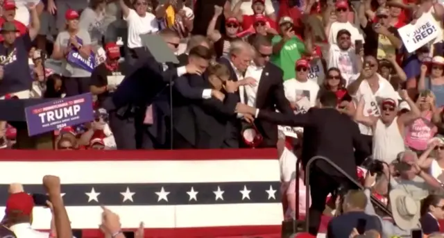 Security escort Republican presidential candidate and former US President Donald Trump away from rally