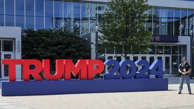 'Trump 2024' sign and a police officer outside convention centre