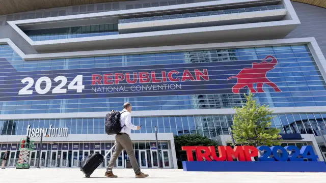 A person walks past signage for the Republican National Convention at Fiserv Forum in Milwaukee