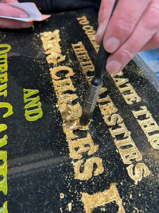 Plaque with gold lettering being added