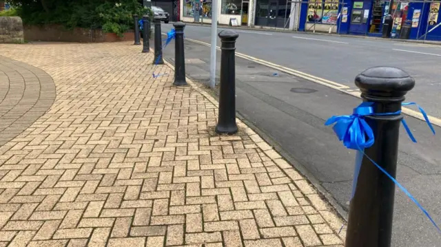 Blue ribbons tied on railings on a road in Oswaldtwistle