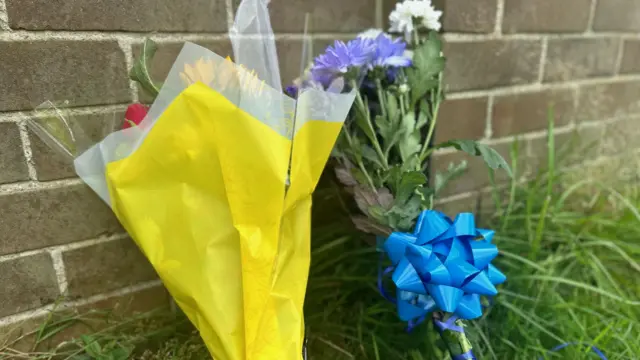 Two bunches of flowers with blue ribbons on one bunch.