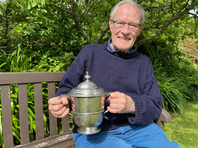 Man holding a silver cup