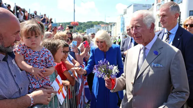 Queen Camilla and King Charles III meeting islanders as they arrive to attend the special sitting of the States in St Peter Port, Guernsey