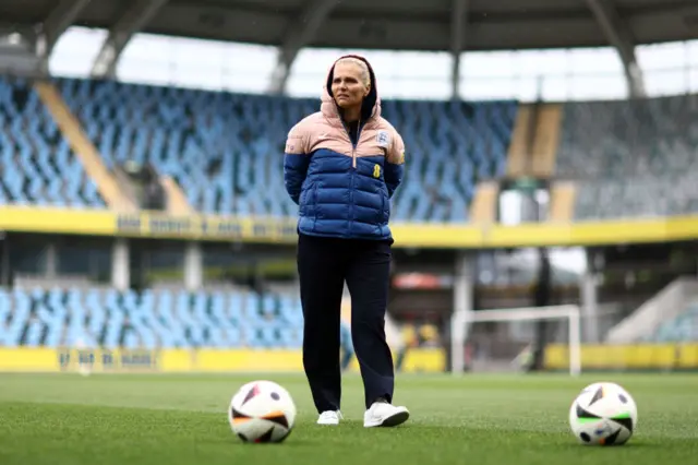 Sarina Wiegman walks around the pitch