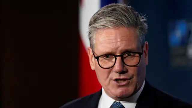 Keir Starmer speaking in front of a Union Jack flag