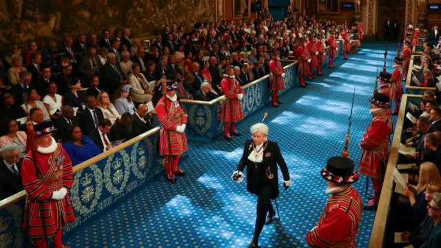 Sarah Clarke, the Black Rod, walks through the Royal Gallery