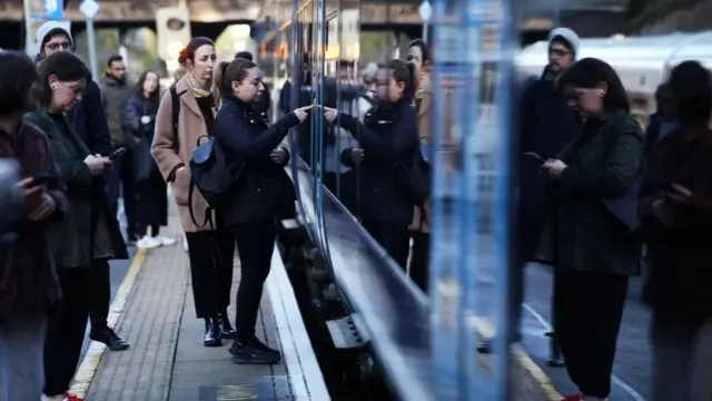 A woman on a platform about to get on a train