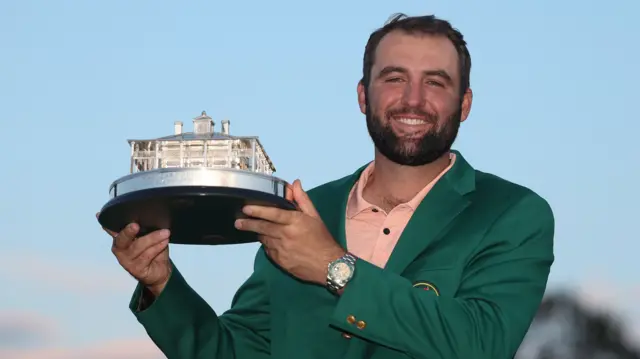 Scottie Scheffler holds the Masters trophy wearing his Green Jacket