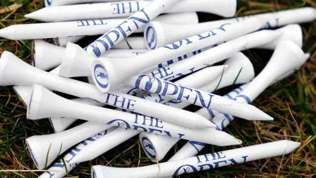 The Open-branded tees in a bundle on the floor