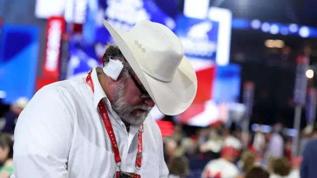 An Arizona delegate wears a bandage in reference to the injury suffered by Republican presidential nominee and former U.S. President Donald Trump in the assassination attempt on Day 3 of the Republican National Convention