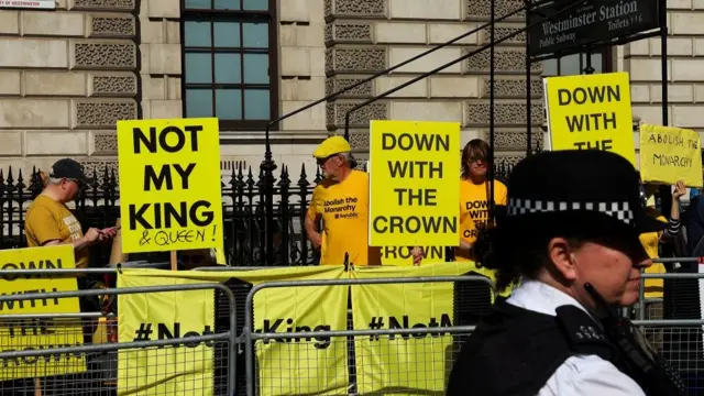 Anti-Royal protesters hold placards near the Houses of Parliament