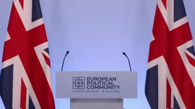 A podium flanked by Union Jack flags