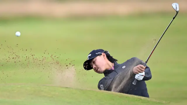 Min Woo Lee plays a shot out of a bunker