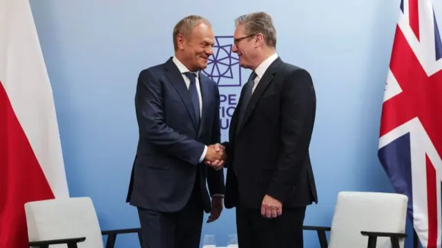 Polish Prime Minister Donald Tusk and British PM Keir Starmer shake hands ahead of their bilateral meeting