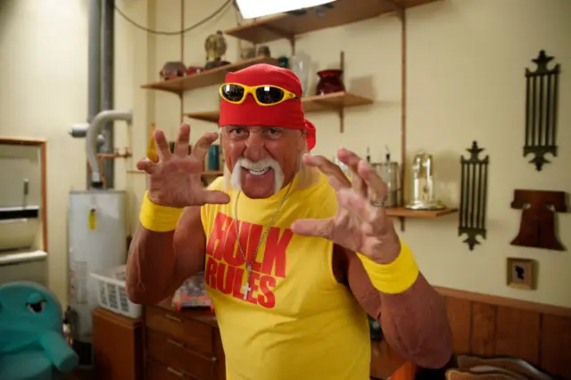 Hulk Hogan poses for a photo with his arms up