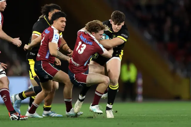 Eddie James of Wales is tackled by Tim Ryan of Queensland Reds