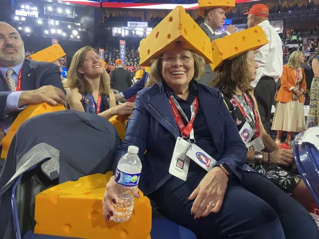 A woman wearing a hat that looks like cheese