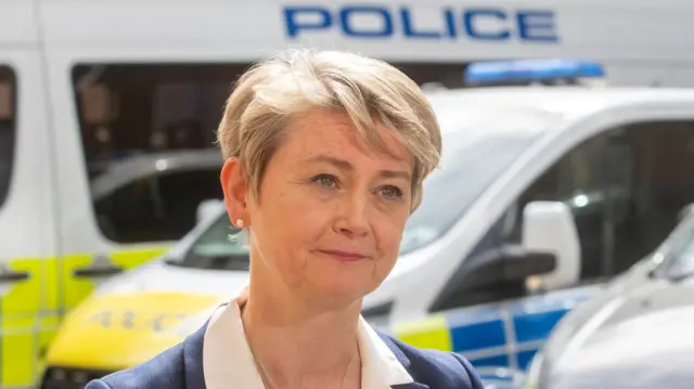 Yvette Cooper in front of police van