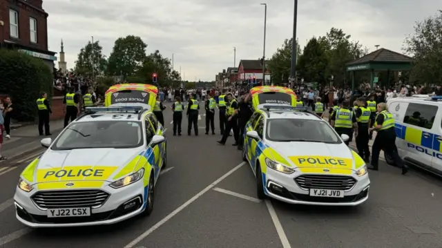 Large numbers of police and police vehicles across the road