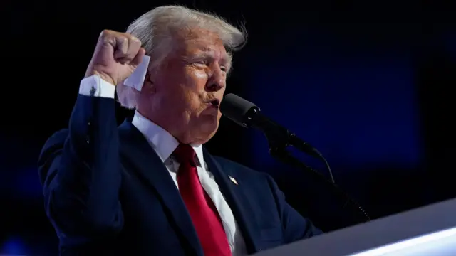 Trump speaking and holding his fist up in the air