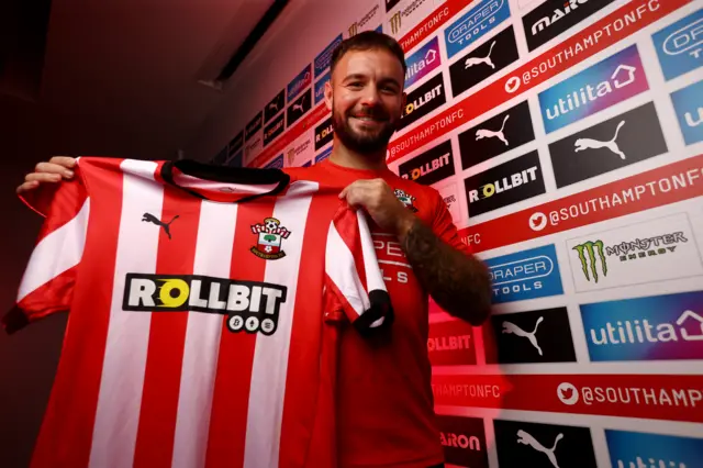 Adam Armstrong holds a Southampton FC shirt