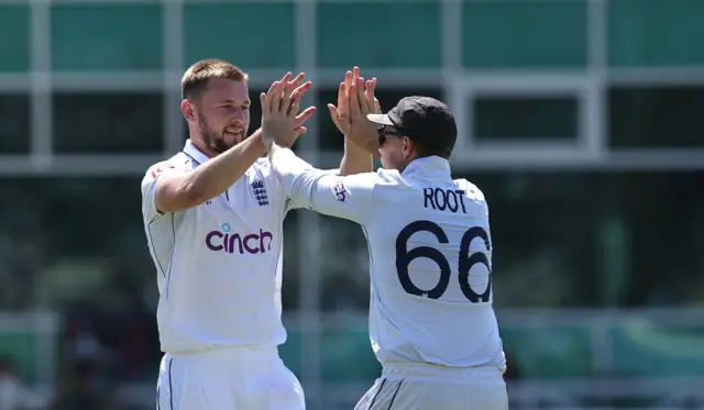 Gus Atkinson celebrates the wicket of Kraigg Brathwaite with Joe Root