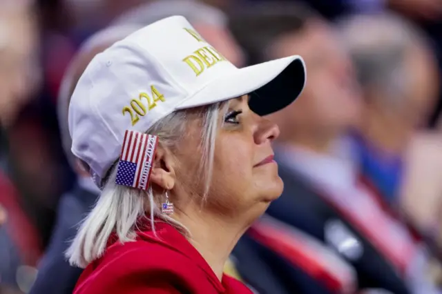 A delegate wears a US flag bandage on her right ear during the fourth day of the Republican National Convention