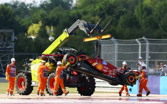 Charles Leclerc's car is taken away by the marshals after his crash