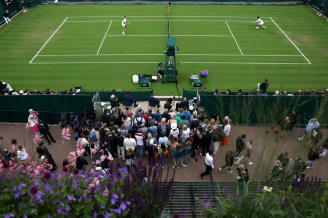 A crowd gather round court 14