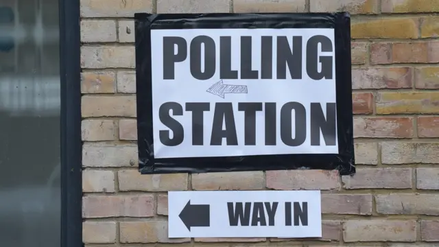 Sign for polling station on brick wall in south London