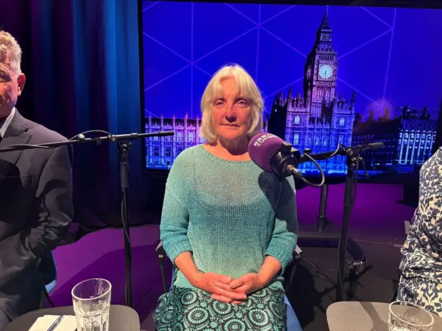 Green Party candidate for Whitehaven and Workington Jill Perry in the ˿ Cumbria election debate studio wearing a fgeen top and patterned green and black skirt