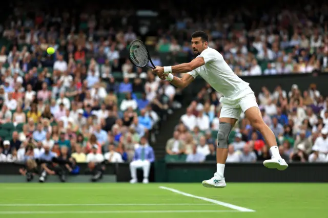 Novak Djokovic jumps into a backhand