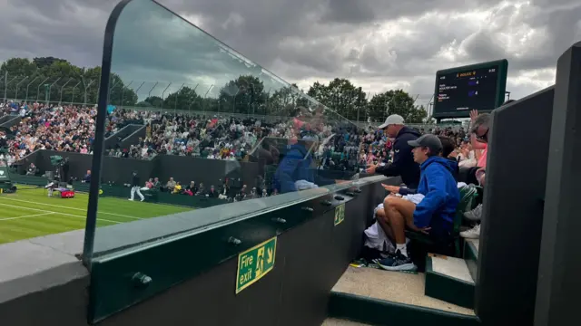 Alex de Minaur watches Katie Boulter on court three