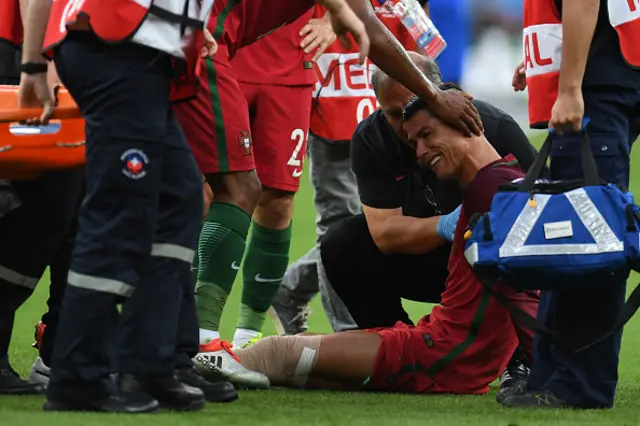 Cristiano Ronaldo (C) cries as he receives medical attention
