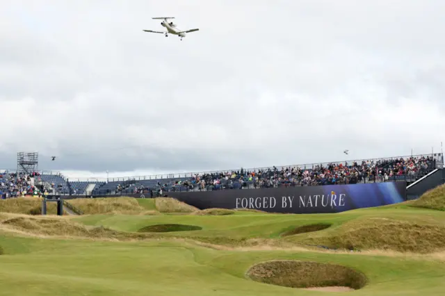 An aeroplane flies over the eighth hole at Royal Troon