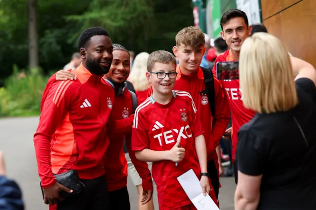 Aberdeen players pose for pictures with a fan