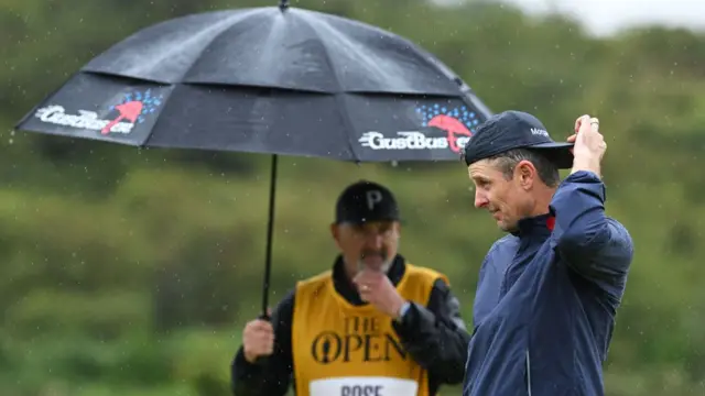 Justin Rose adjusts his cap