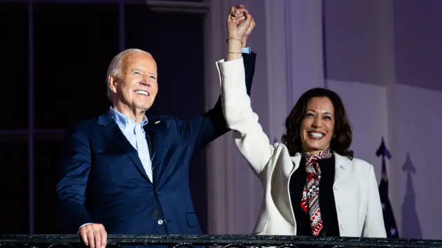 Biden and Harris link hands in the air