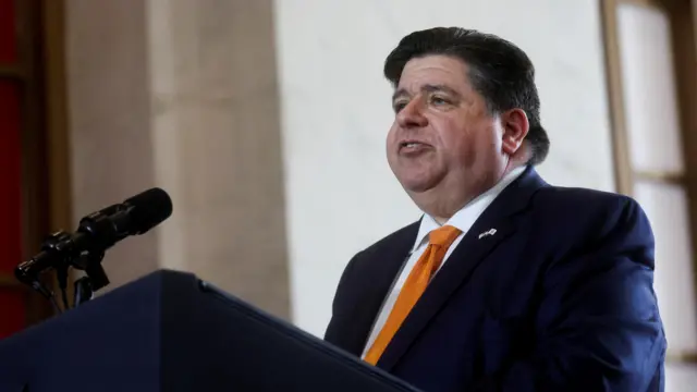 JB Pritzker speaks into a microphone