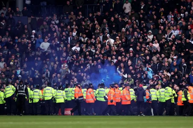 The game is delayed for 30 minutes as Police Officers and Stewards attempt to stop a disruption