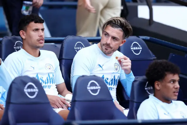 Jack Grealish sitting on the Manchester City bench