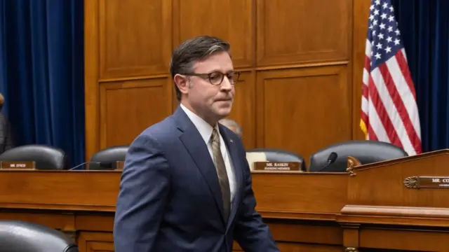 Republican House Speaker Mike Johnson wearing a suit and glasses